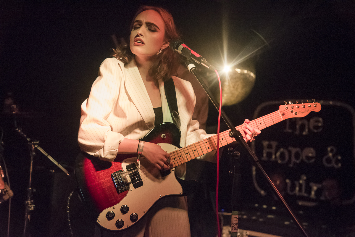 Image of Maddy Storm playing the guitar.